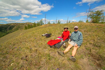 man and woman Tourists on a picnic on the ridge of the Ural Mountains on a summer sunny day