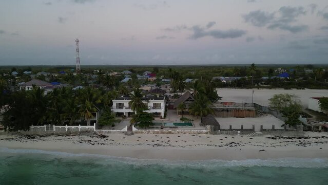 Uroa beach homes and bungalows in Zanzibar Island Tanzania Africa, Aerial top view dolly out reveal shot