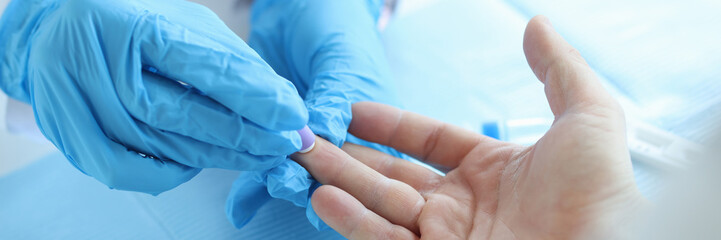 Nurse lab technician in gloves, using painless scarifier to prick finger of patient - obrazy, fototapety, plakaty