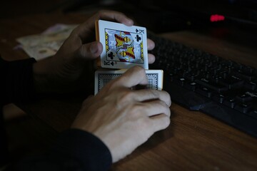 card in hand.
man holding cards in hand , under the concept of online gambling