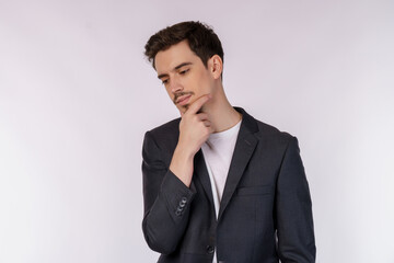 Portrait of young businessman thinking touching chin isolated over white background