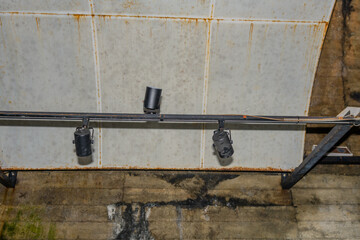 Black metal track lights with rusted metal panels inside old re-purposed mining tunnel.