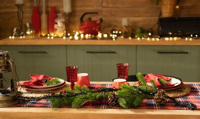 Christmas and New Year 2023, a beautiful setting of the New Year's table in red, against the background of a decorated Christmas tree and a window with a winter landscape