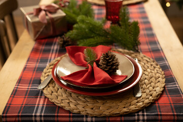 Christmas and New Year 2023, a beautiful setting of the New Year's table in red, against the background of a decorated Christmas tree and a window with a winter landscape