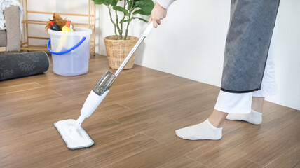 Beautiful clean housewife is mopping the floor in the living room, Big cleaning in the house,...