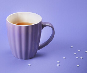 A cup of tea with sweetener.