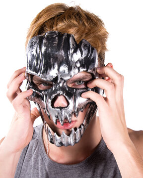 Young attractive guy posing in the studio in a mask. Halloween holiday.
