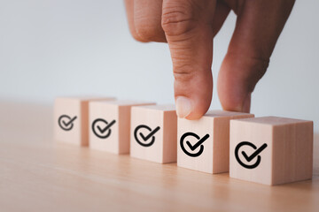 Put wooden cube with check mark icon. Corporate regulatory and compliance. Quality control...