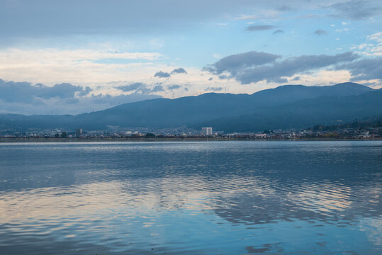 朝の湖面に映る青空と雲と山