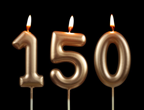 Burning golden birthday candles isolated on black background, number 150