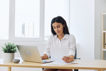 Woman business works at her laptop at home in her office, freelance employee in business, problems with work and paperwork