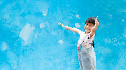 Banner of cute 5 years old asian little girl is smiling while painting the wall with water color at home, concept of art education for kid, homeschooling and learning activity by playing for child.