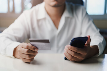 Businessman using smartphone and hand hold credit card pay web shopping online The promotion Black friday, Cyber monday. Shop for cheap products sale from website online stores.