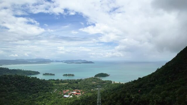 Panorama Of Calm Blue Ocean With View Of Cable Cars Moving Over Lush Mountains In Langkawi Island, Malaysia. aerial pan left