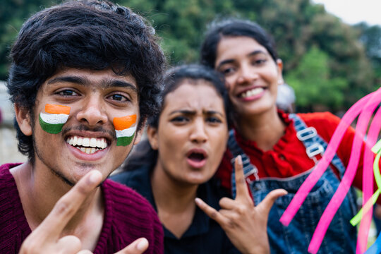 focus on boy, cheerful excited happy friends with painted indian flag on face shouting during watching sports at stadium after win - concept of friendship, celebrating victory and fans.