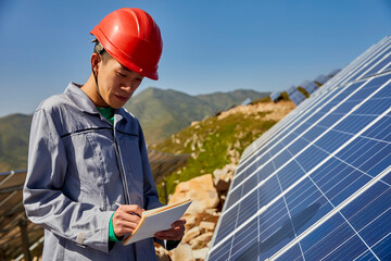 Asian engineers inspecting the solar photovoltaic area