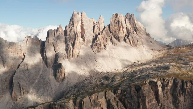 Distinctive jagged peaks of Croda da Lago stand out against blue sky; aerial