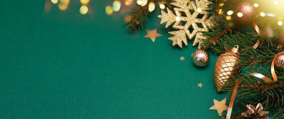   Spruce, fir branches, baubles and snowflake on green  textured background. Frame border....