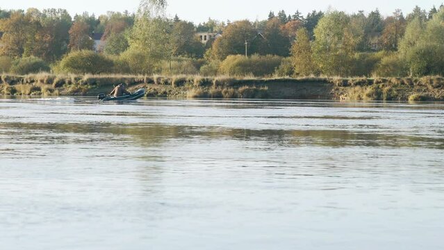 The fisherman floats in the morning on the river on a motor boat. Vacation and hobby concept.