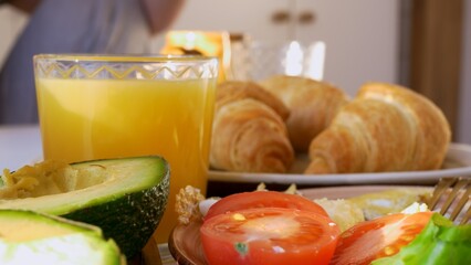 Close-up breakfast, a full breakfast with croissants and scrambled eggs with vegetables, fruits, everything you need to keep your body in good shape. Proper nutrition is the key to success and health.