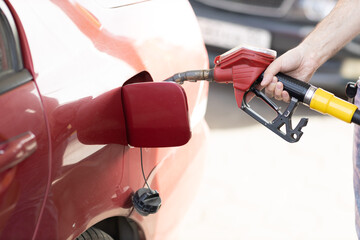 Man holding filling pistol in his hand at gas station