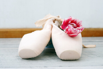 pointe shoes for a ballerina with a pink flower.