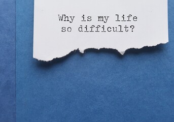 Torn paper on blue book with text typed question - Why is my life so difficult? -  emotional...