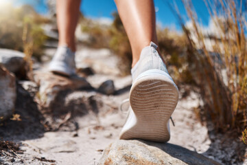 Shoes, hiking and fitness with a woman closeup walking up a mountain trail for exercise, cardio or...
