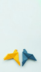 two doves made of origami paper in yellow and blue, in colors of Ukrainian flag on background, vertical, 16:9,