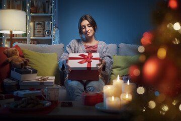 Happy woman opening Christmas gifts