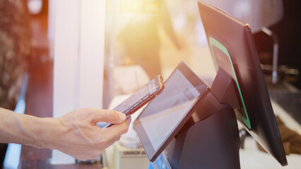 Close up man uses mobile phone to scan QR code for payment