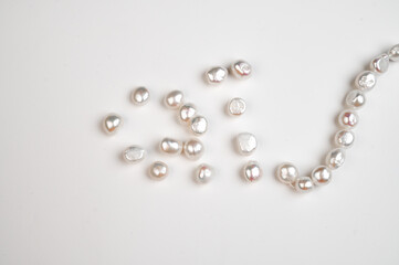 Natural freshwater round baroque pearl beads on white background. Top view