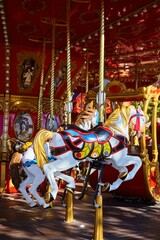 Fototapeta na wymiar Carousel with horses in the city park. Entertainment for children.
