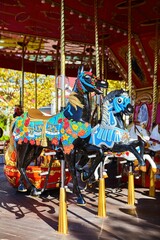 Fototapeta na wymiar Carousel with horses in the city park. Entertainment for children.