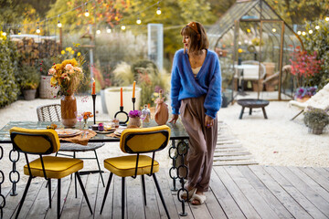 Woman near decorated table at backyard