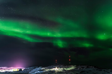 Aurora borealis on the coast of the Barents Sea in the sky over the village of Teriberka, Murmansk region. Russia