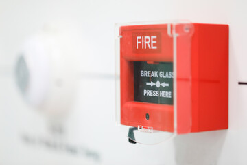 Fire alarm box install on the white wall.