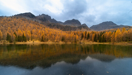 Fototapeta na wymiar Amazing Autumn landscape on mountians lake. Dolomites Italy