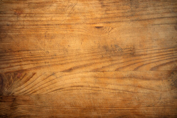 The background is made of an old yellow wooden board. Wooden countertop on the kitchen table in the village.A panel for throwing knives.