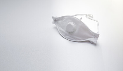 A white mask to protect against pungent odors. Construction dust mask on a white background. Bursting with a white lid.