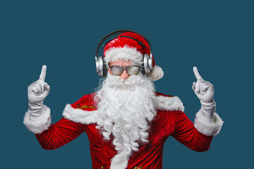 Cool Santa Claus is listening music in headphones