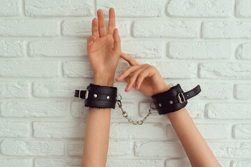Female hand in black handcuffs for sex games