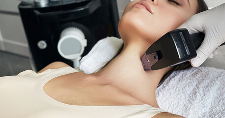 Close-up RF neck lifting procedure for young woman for tightening and improving the condition of...