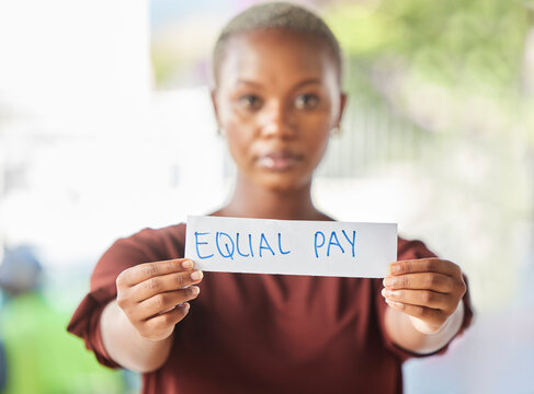 Equal pay, paper sign and black woman protest for women work salary rights outdoor. Portrait of a young person from Africa with serious protesting for female worker empowerment and equality