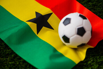 Ghana national football team. National Flag on green grass and soccer ball. Football wallpaper for Championship and Tournament in 2022. World international match.