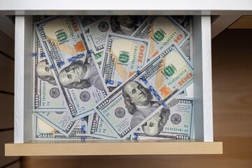 a hundred dollar bill is in a drawer.