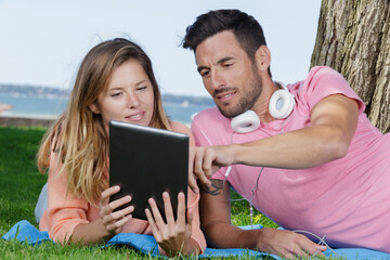 happy couple in love lying in the park