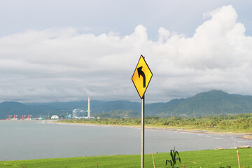 Left Turn Sign with Coast and Mountain Scenery in Sukabumi, West Java, Indonesia