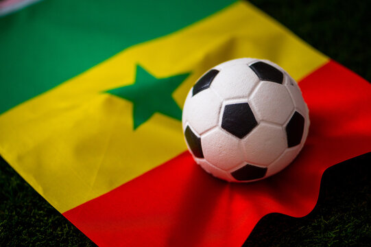 Senegal national football team. National Flag on green grass and soccer ball. Football wallpaper for Championship and Tournament in 2022. World international match.