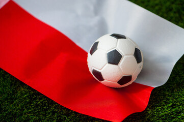 Poland national football team. National Flag on green grass and soccer ball. Football wallpaper for Championship and Tournament in 2022. World international match.